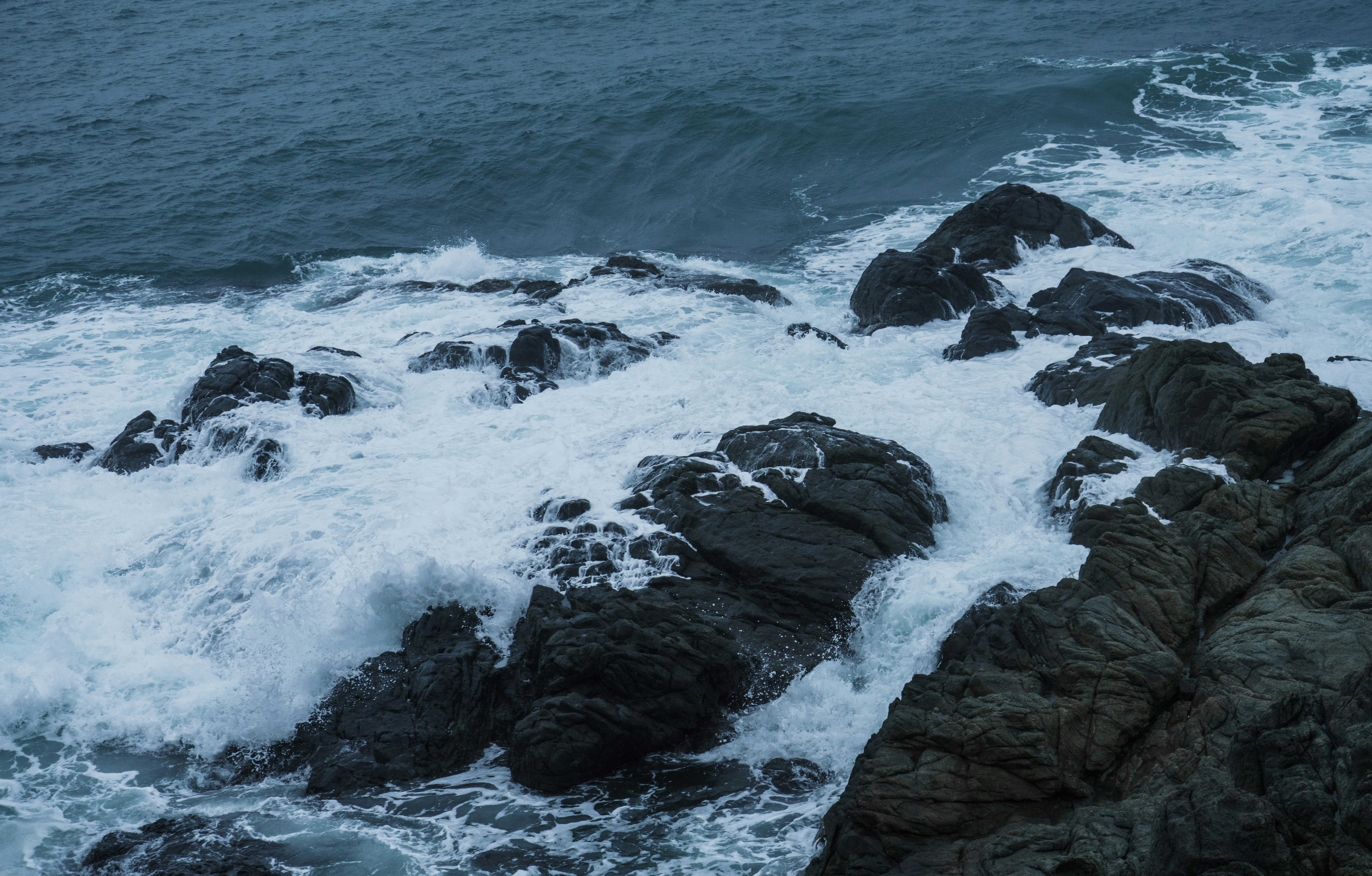 rocky shore with ocean waves during daytime